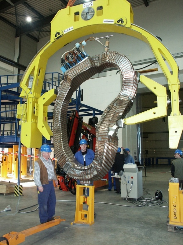 Die erste von insgesamt 50 Stellarator-Magnetspulen ist in Greifswald angekommen. Das Foto zeigt die Spule eingehängt in ein drehbares Gestell, mit dessen Hilfe die Spulen bei der Montage über das Plasmagefäß gefädelt werden.