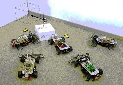 Miteinander kooperierende Roboterfahrzeuge, die untereinander Sensorinformationen austauschen, um eine Kiste in die Ecke zu schieben. Fotos: Institut für Informatik, Uni Würzburg
