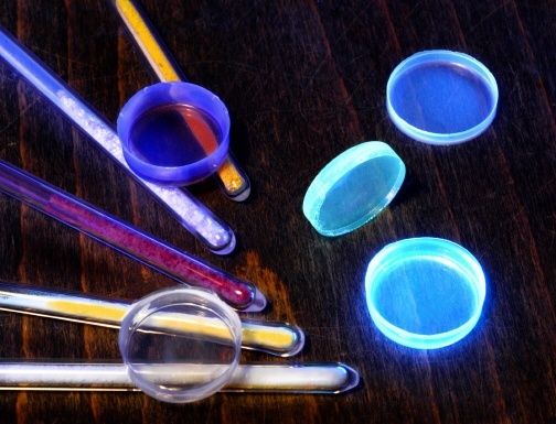 Fluoreszierende Nanopartikel leuchten unter UV-Licht in verschiedenen Intensitäten und Farben. Die mehrschichtigen Partikel wurden mit dem im Forschungszentrum Karlsruhe entwickelten Mikrowellen-Plasmaverfahren hergestellt.
