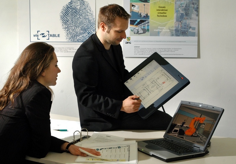 Anne-Kathrin Fuchs vom Verein Marketing zwischen Theorie und Praxis und Uwe Günther von der Professur Fabrikplanung und Fabrikbetrieb der TU Chemnitz bei der Vorbereitung des Messeauftritts des Planungssystems "visTable" (Foto: TUC/Uwe Meinhold).